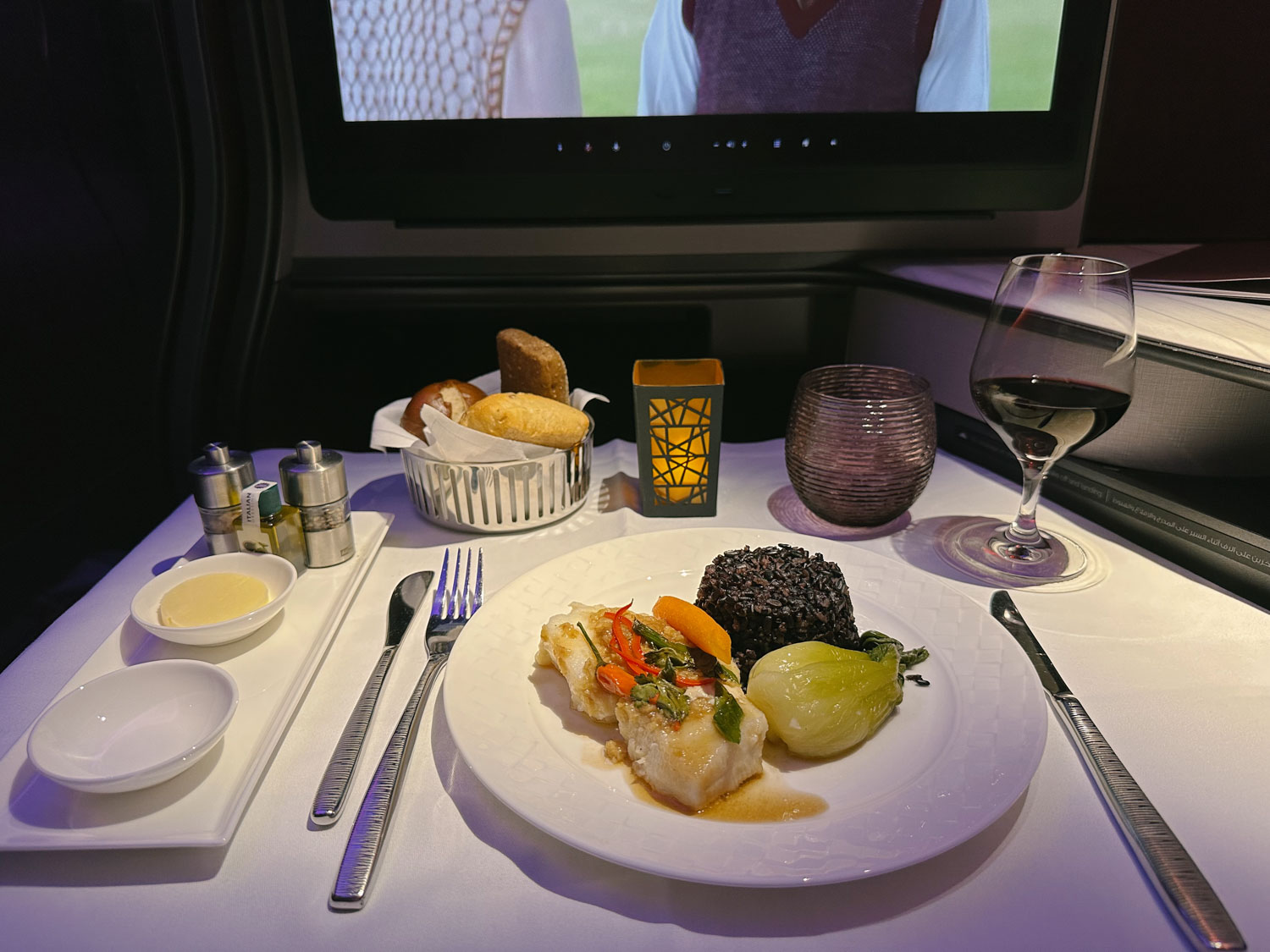 qatar qsuites inflight dining dinner sea bass with forbidden rice and red wine