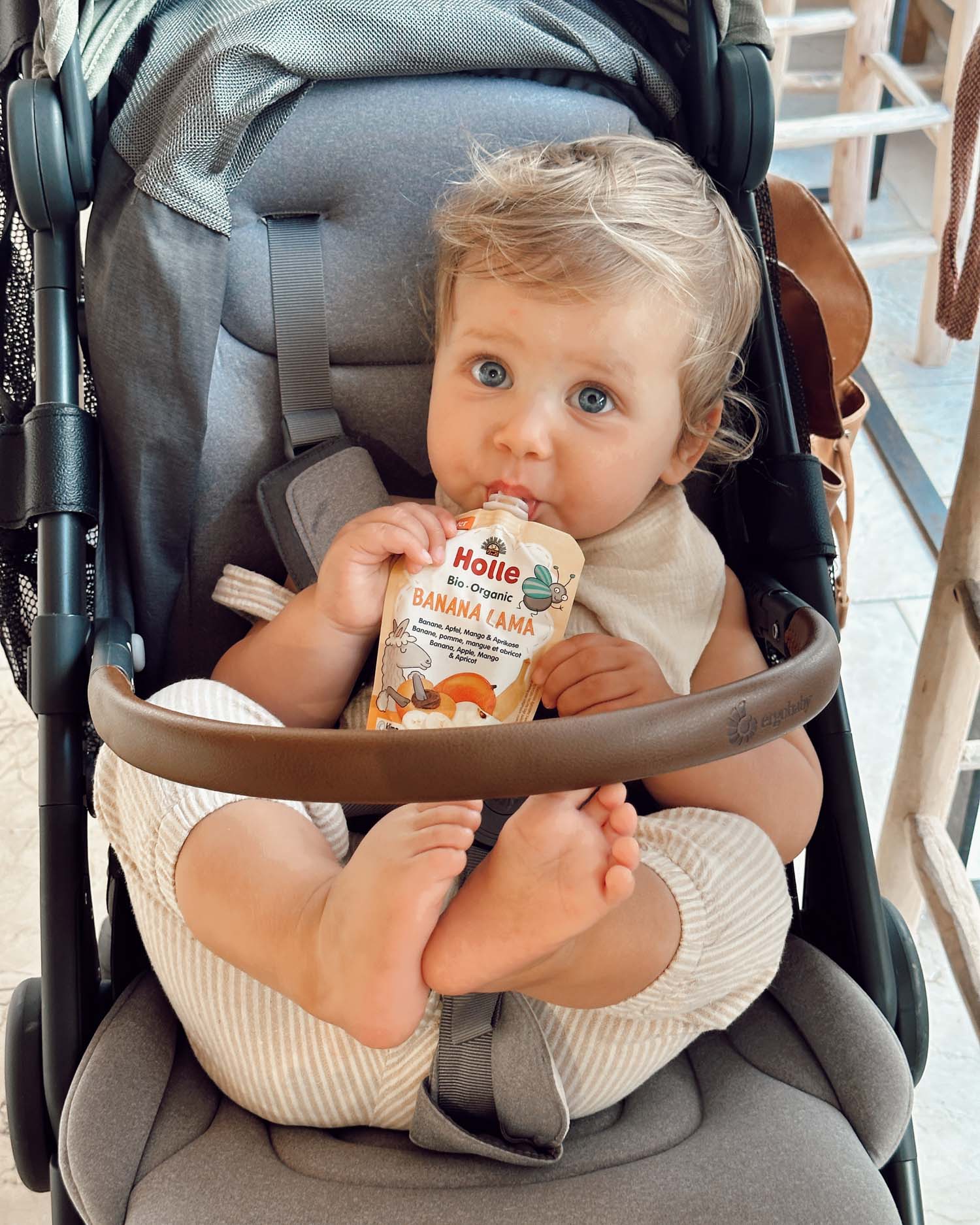 blue eyed baby with pouch in stroller little toes