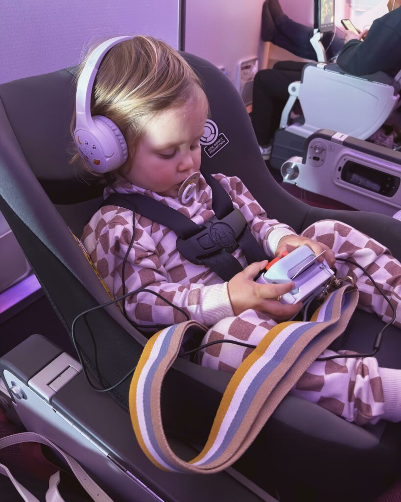 toddler listening to a YoTo mini with headphones on a plane