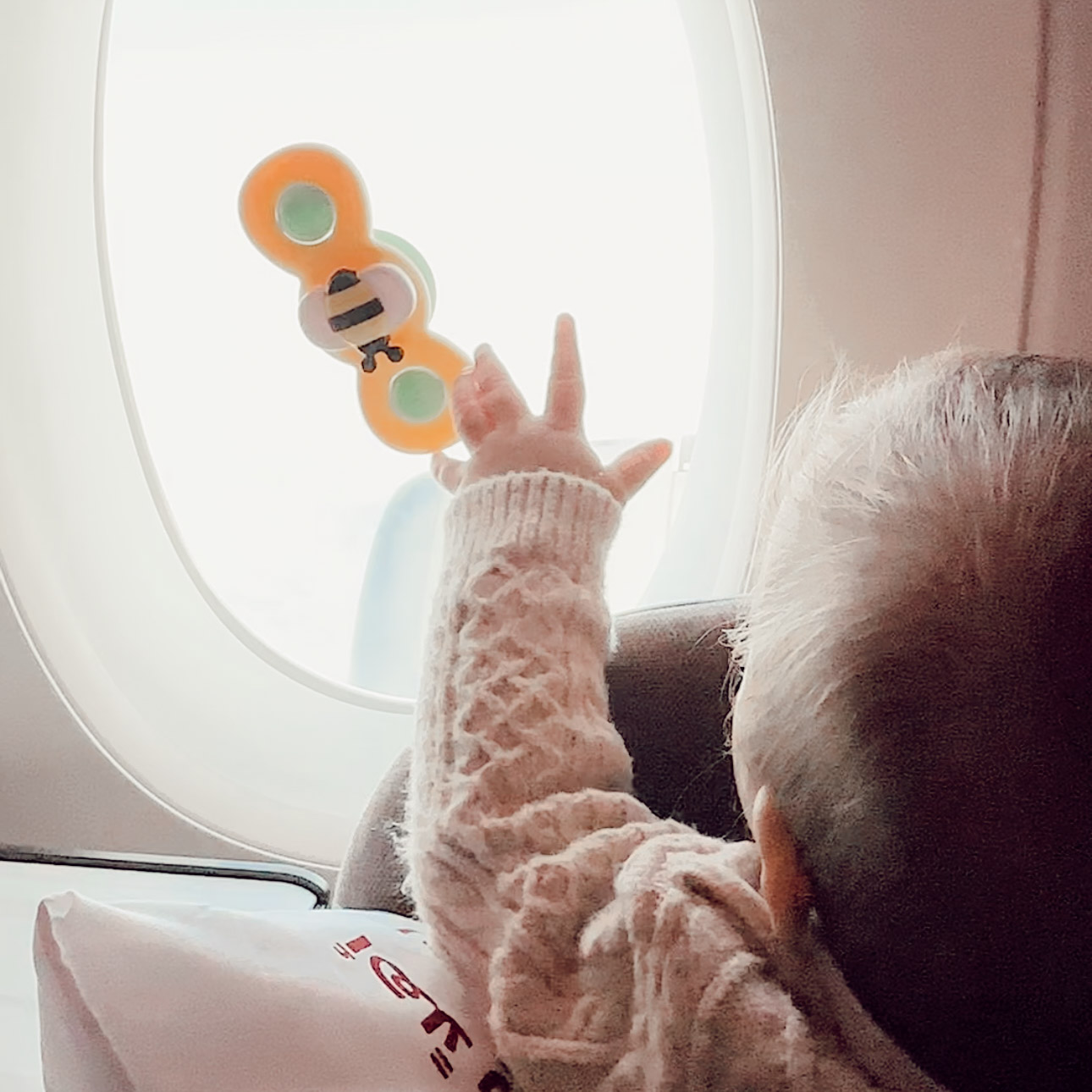 baby spinning suction toy on window seat in airplane