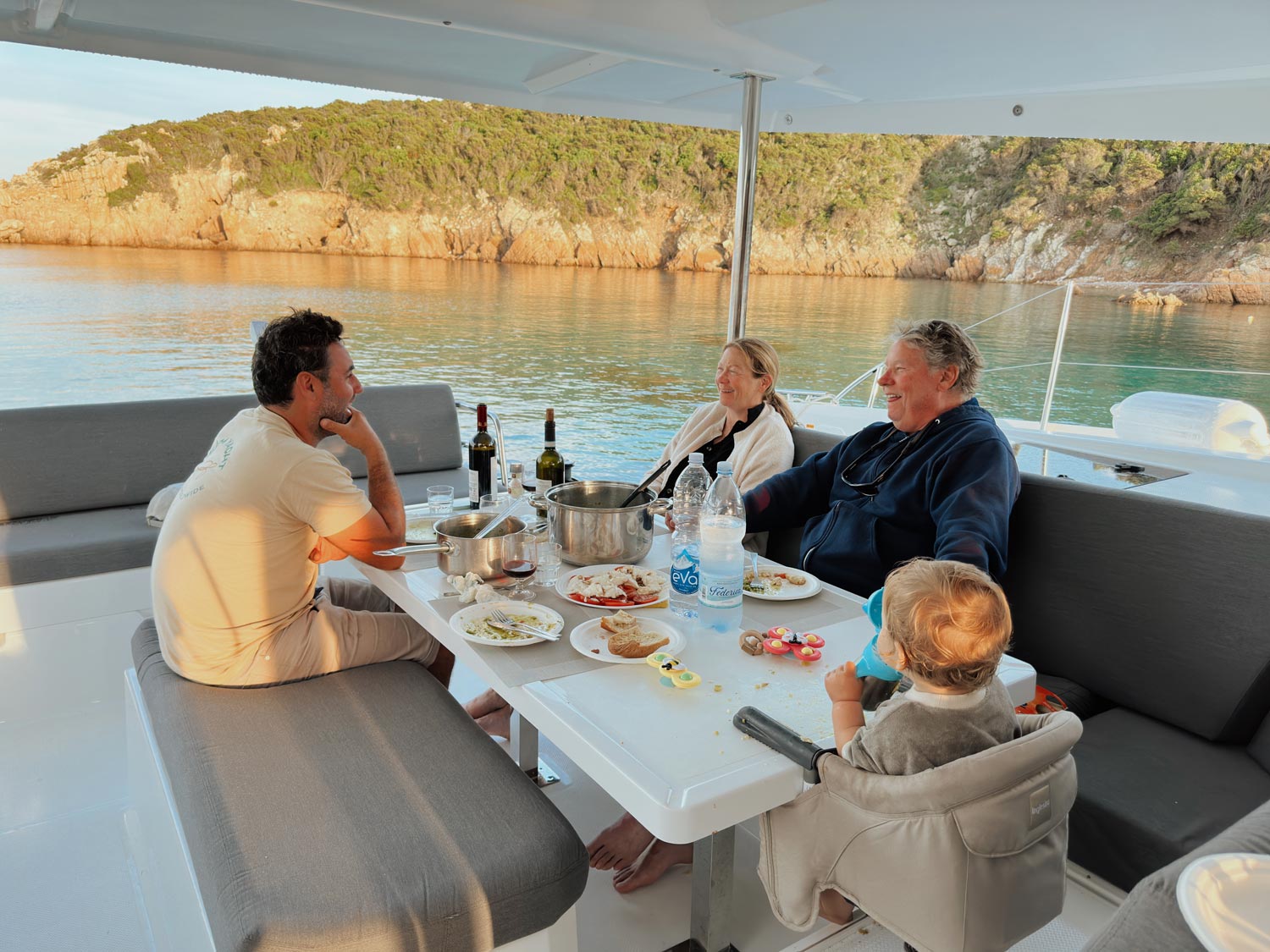 skipper joining family for dinner on catamaran yacht charter with baby